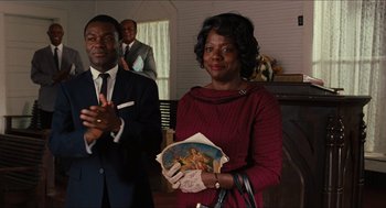 Movie still from “The Help” (2011), directed by Tate Taylor – An older woman holding an old picture in front of two men; Medium shot, Over the shoulder angle