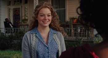 Movie still from “The Help” (2011), directed by Tate Taylor – A woman with long curly hair smiling for the camera; Close Up shot, Over the shoulder angle