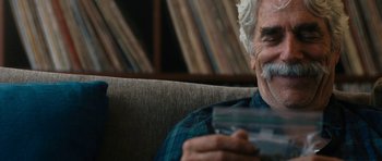 Movie still from “The Hero” (2017), directed by Brett Haley – An older man sitting on a couch holding a cup; Close Up shot, Over the shoulder angle