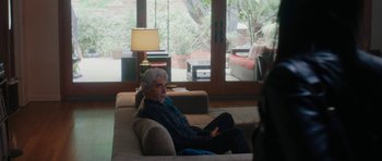 Movie still from “The Hero” (2017), directed by Brett Haley – An older man sitting on a couch in a living room; Wide shot, Over the shoulder angle