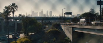 Movie still from “The Hero” (2017), directed by Brett Haley – A view of a city from a bridge over a river; Extreme Wide shot, High angle