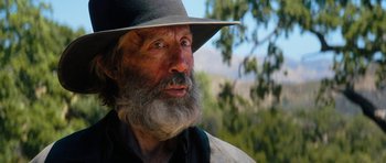 Movie still from “The Hero” (2017), directed by Brett Haley – An old man with a gray beard wearing a hat; Close Up shot, Over the shoulder angle