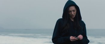 Movie still from “The Hero” (2017), directed by Brett Haley – A woman wearing a black hoodie standing next to the ocean; Close Up shot, Over the shoulder angle