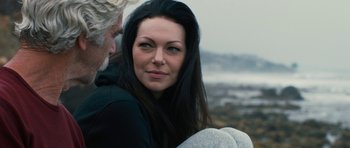 Movie still from “The Hero” (2017), directed by Brett Haley – A person sitting on the ground near a body of water; Close Up shot, Over the shoulder angle