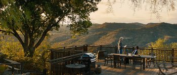 Movie still from “The Hero” (2017), directed by Brett Haley – An outdoor deck with a view of the mountains; Extreme Wide shot, High angle