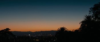 Movie still from “The Hero” (2017), directed by Brett Haley – A view of a city at dusk or dawn; Extreme Wide shot, Low angle