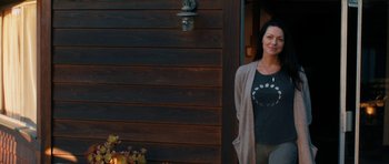Movie still from “The Hero” (2017), directed by Brett Haley – A woman standing in front of a wooden wall; Medium shot, Over the shoulder angle