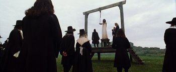 Movie still from “Practical Magic” (1998), directed by Griffin Dunne – A group of people standing in front of a guillotine; Wide shot, Low angle