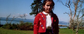 Movie still from “Practical Magic” (1998), directed by Griffin Dunne – A young girl wearing a red sweater and a white shirt; Close Up shot, Low angle