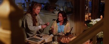 Movie still from “Practical Magic” (1998), directed by Griffin Dunne – Two women sitting at a table with food; Medium shot, High angle