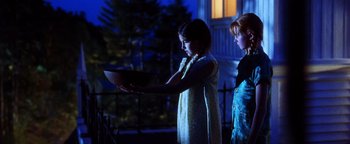 Movie still from “Practical Magic” (1998), directed by Griffin Dunne – Two young girls standing in front of a building; Medium shot, Low angle