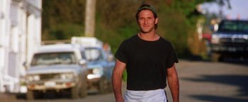 Movie still from “Practical Magic” (1998), directed by Griffin Dunne – A man in a black shirt is walking down the street; Medium shot, Low angle