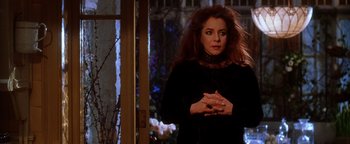 Movie still from “Practical Magic” (1998), directed by Griffin Dunne – A woman standing in front of an open door; Medium shot, Over the shoulder angle