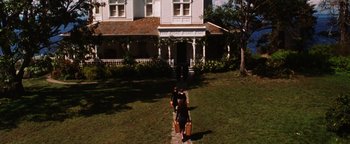Movie still from “Practical Magic” (1998), directed by Griffin Dunne – Two people walking down a path in front of a house; Extreme Wide shot, High angle