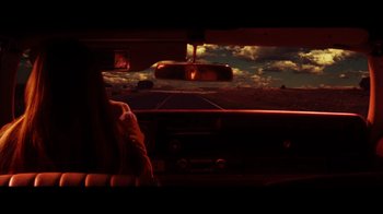 Movie still from “Practical Magic” (1998), directed by Griffin Dunne – A view from a car looking out the windshield at a sunset; Wide shot, Low angle