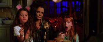Movie still from “Practical Magic” (1998), directed by Griffin Dunne – Two women sitting at a table with a plate of food in front of them; Medium shot, Over the shoulder angle