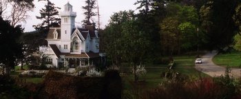 Movie still from “Practical Magic” (1998), directed by Griffin Dunne – A large white house sitting on top of a lush green field; Extreme Wide shot, Low angle