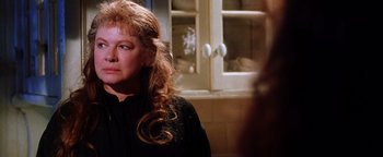 Movie still from “Practical Magic” (1998), directed by Griffin Dunne – A woman with long red hair standing in front of a window; Close Up shot, Over the shoulder angle