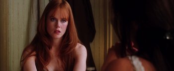 Movie still from “Practical Magic” (1998), directed by Griffin Dunne – A woman with long red hair looking into a mirror; Close Up shot, Over the shoulder angle