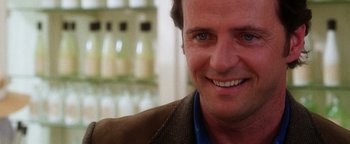 Movie still from “Practical Magic” (1998), directed by Griffin Dunne – A man smiling for the camera; Close Up shot, Over the shoulder angle