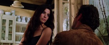Movie still from “Practical Magic” (1998), directed by Griffin Dunne – A beautiful young woman standing in front of an open window; Close Up shot, Over the shoulder angle