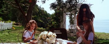 Movie still from “Practical Magic” (1998), directed by Griffin Dunne – A woman sitting at a table with a little girl; Medium shot, Over the shoulder angle