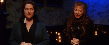 Movie still from “Practical Magic” (1998), directed by Griffin Dunne – Two women sitting next to each other in front of candles; Close Up shot, Over the shoulder angle