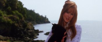 Movie still from “Practical Magic” (1998), directed by Griffin Dunne – A woman holding a black cat near a body of water; Close Up shot, Low angle