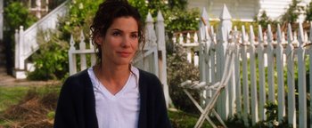 Movie still from “Practical Magic” (1998), directed by Griffin Dunne – A woman standing in front of a white picket fence; Close Up shot, Over the shoulder angle