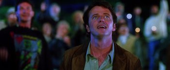 Movie still from “Practical Magic” (1998), directed by Griffin Dunne – A person looking up at a crowd of onlookers; Close Up shot, Low angle