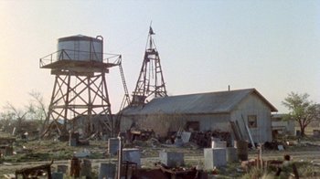 Movie still from “The Hills Have Eyes” (1977), directed by Wes Craven – An old building with a water tower in the background; Extreme Wide shot, Low angle