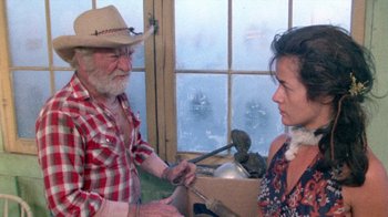 Movie still from “The Hills Have Eyes” (1977), directed by Wes Craven – An old man and a woman are looking at each other; Medium shot, High angle