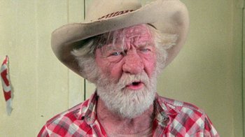 Movie still from “The Hills Have Eyes” (1977), directed by Wes Craven – An old man with a white beard wearing a cowboy hat; Close Up shot, High angle