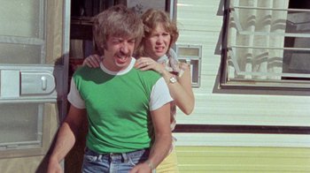 Movie still from “The Hills Have Eyes” (1977), directed by Wes Craven – A man and a woman standing next to each other; Medium shot, Low angle