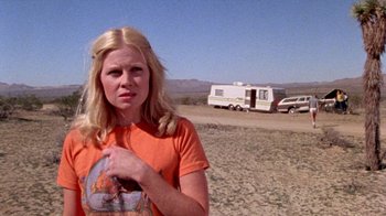 Movie still from “The Hills Have Eyes” (1977), directed by Wes Craven – A woman standing in the middle of a dirt field; Medium shot, Low angle