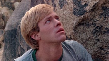 Movie still from “The Hills Have Eyes” (1977), directed by Wes Craven – A man with blonde hair looking up into the sky; Close Up shot, Low angle