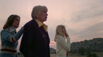 Movie still from “The Hills Have Eyes” (1977), directed by Wes Craven – Two people standing next to each other on a field; Medium shot, Low angle