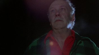 Movie still from “The Hills Have Eyes” (1977), directed by Wes Craven – An old man with a red shirt is looking up at the sky; Close Up shot, Low angle