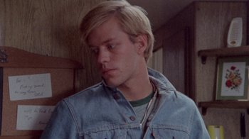 Movie still from “The Hills Have Eyes” (1977), directed by Wes Craven – A man in a jean jacket looking down at his face; Close Up shot, Over the shoulder angle