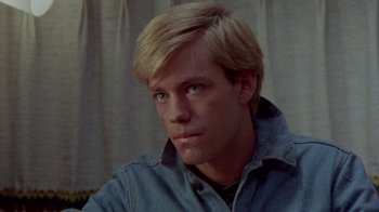 Movie still from “The Hills Have Eyes” (1977), directed by Wes Craven – A person with blond hair; Close Up shot, High angle
