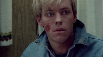 Movie still from “The Hills Have Eyes” (1977), directed by Wes Craven – A person with a bruise on his face; Close Up shot, High angle