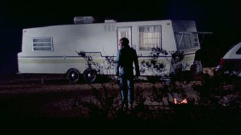 Movie still from “The Hills Have Eyes” (1977), directed by Wes Craven – A man standing in front of an rv at night; Wide shot, Low angle