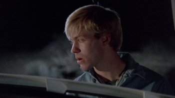 Movie still from “The Hills Have Eyes” (1977), directed by Wes Craven – A man with blonde hair is sitting in a car; Close Up shot, Over the shoulder angle
