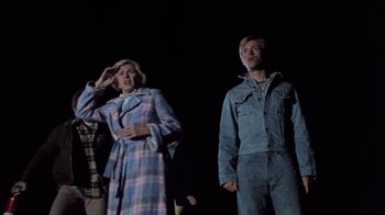 Movie still from “The Hills Have Eyes” (1977), directed by Wes Craven – A group of people standing on a stage in front of a black background; Medium shot, Low angle