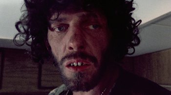 Movie still from “The Hills Have Eyes” (1977), directed by Wes Craven – A person with a beard; Extreme Close Up shot, Low angle