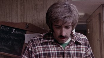 Movie still from “The Hills Have Eyes” (1977), directed by Wes Craven – A man with a beard and mustache wearing a plaid shirt; Close Up shot, High angle