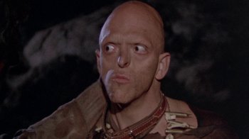 Movie still from “The Hills Have Eyes” (1977), directed by Wes Craven – A man with a bald head is looking at the camera; Close Up shot, Low angle