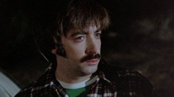 Movie still from “The Hills Have Eyes” (1977), directed by Wes Craven – A person with a mustache; Close Up shot, High angle