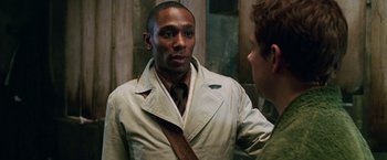 Movie still from “The Hitchhiker's Guide to the Galaxy” (2005), directed by Garth Jennings – A man wearing a white jacket and a brown neck tie; Close Up shot, Over the shoulder angle