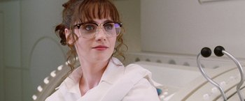 Movie still from “The Hitchhiker's Guide to the Galaxy” (2005), directed by Garth Jennings – A person wearing glasses and a white shirt; Close Up shot, Over the shoulder angle